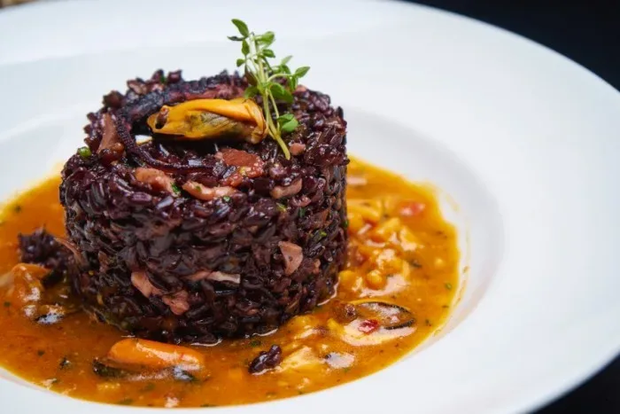 Tortino di riso di Venere allo zafferano in guazzetto di frutti di mare