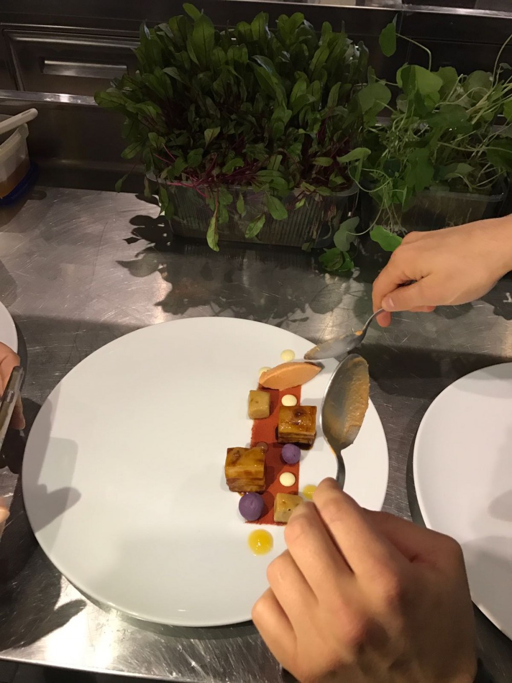 Preparazione del piatto con chenelle di gelato di pomodoro