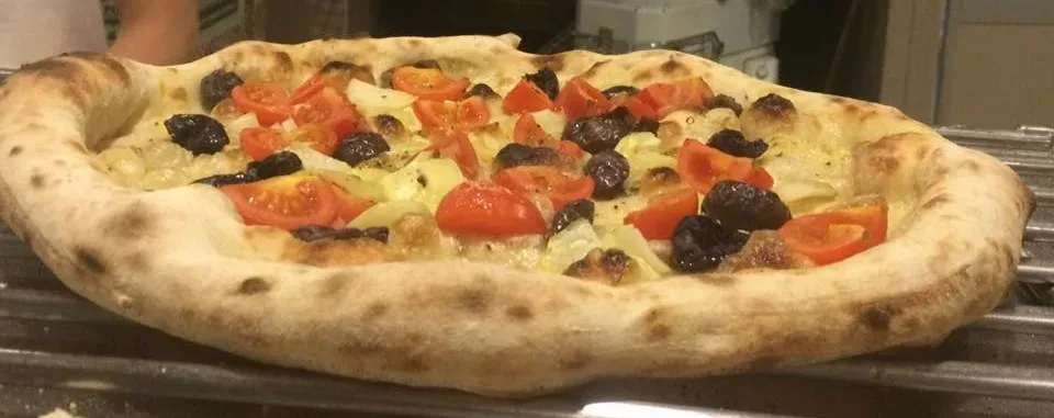 Tonda, pizza in uscita dal forno a legna