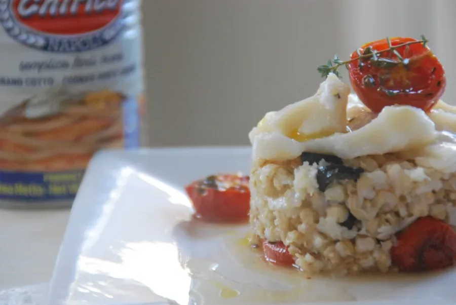 Tortino di grano con olive nere, pomodorini confit al timo e petali di baccala'
