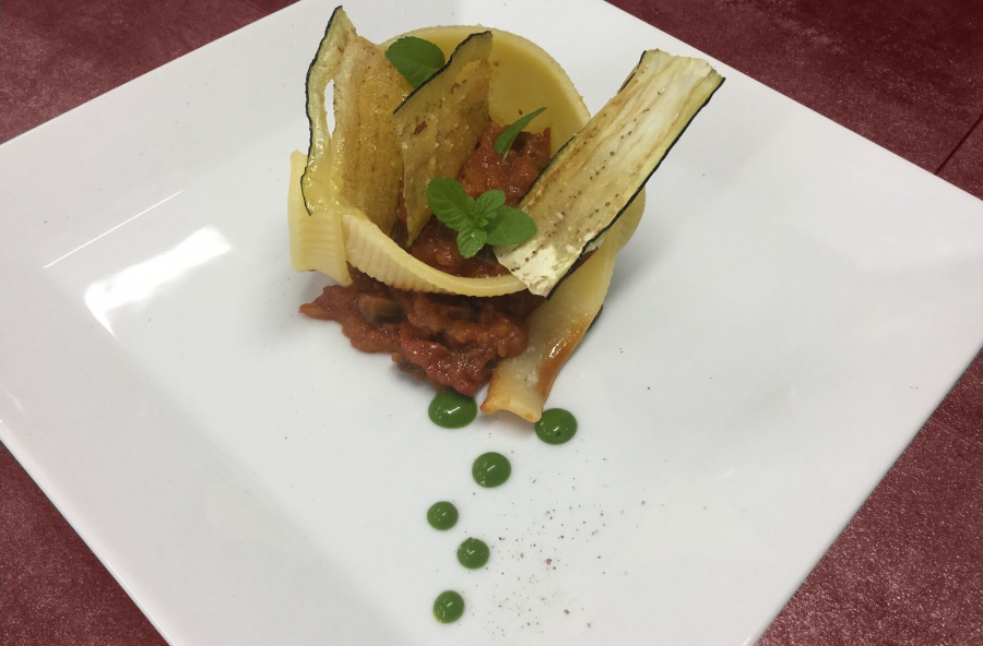 Conchiglione di pasta su pesto ripieno di pomodorini e melanzane