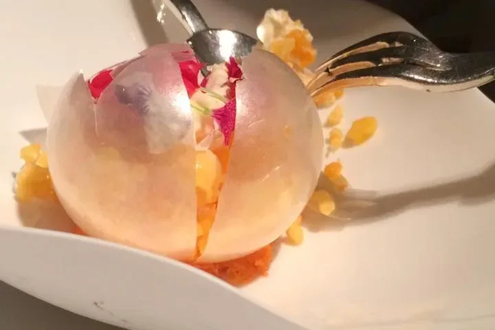 Cromatismo di arancia. Arancia in buccia e cristalli gelati frutta, verdura caramello e petali di fiori