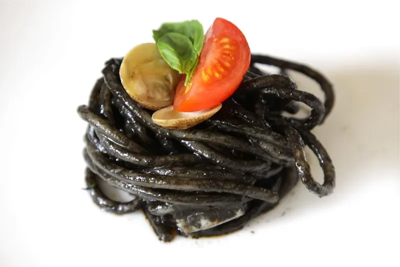 Pasta al nero di seppia, pesto, scampi e lupini