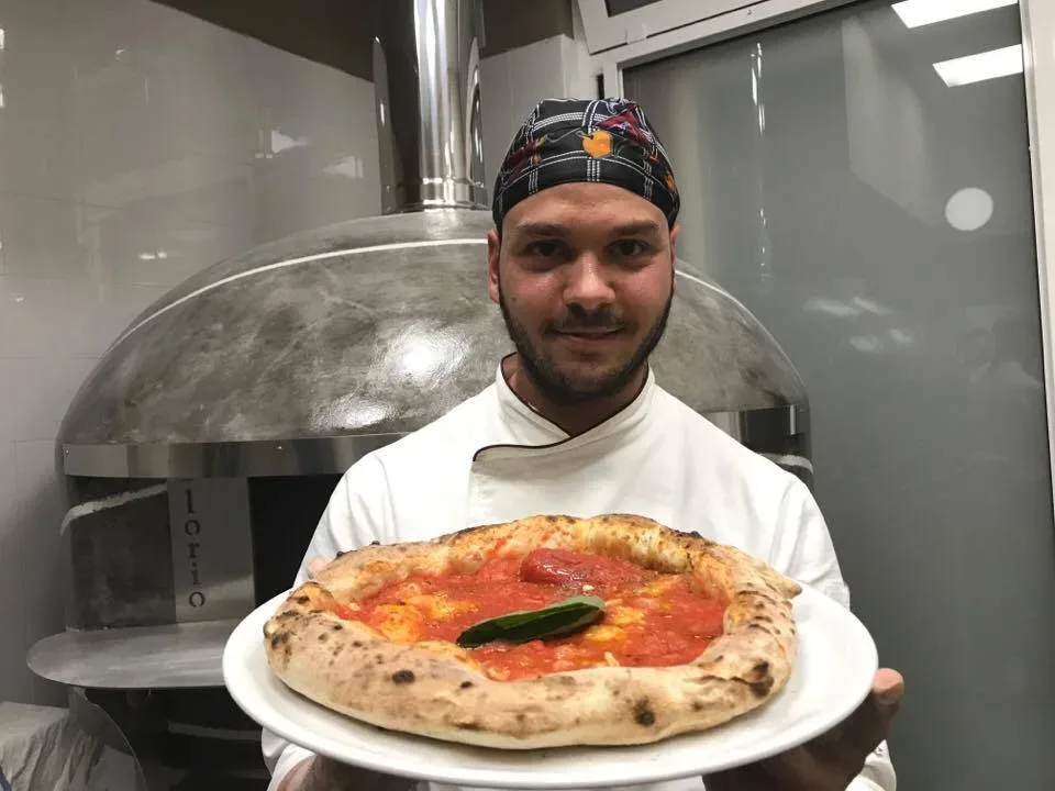 Pepo Gianluigi Castiello il pizzaiolo con la pizza marinara