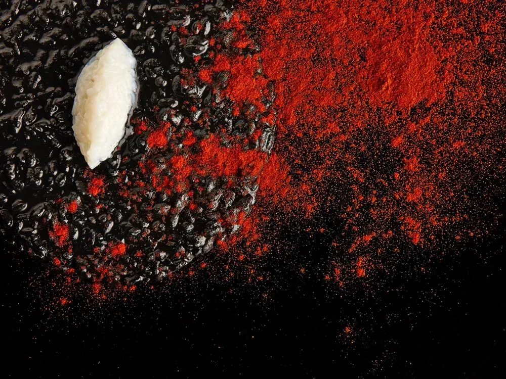 Risotto al nero, crudo di seppie e polvere di peperoni canditi