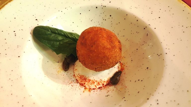 Lilo Libero Locale, polpetta con baccalà mantecato e patate su burrata al tartufo, polvere di peperone, cacioricotta del Cilento e oliva salella ammaccata