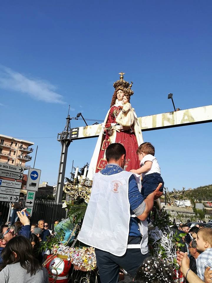 La Madonna ed un bambino che viene avvicinato alla statua