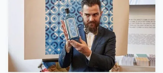 Adriano Attus con la bottiglia di SAPPHIRE BOMBAY e il pattern da lui creato