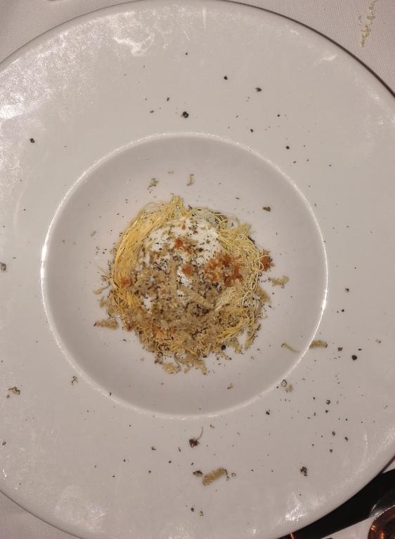 Uovo in pasta kataifi su crema di parmigiano con polvere di prosciutto e tartufo uncinato