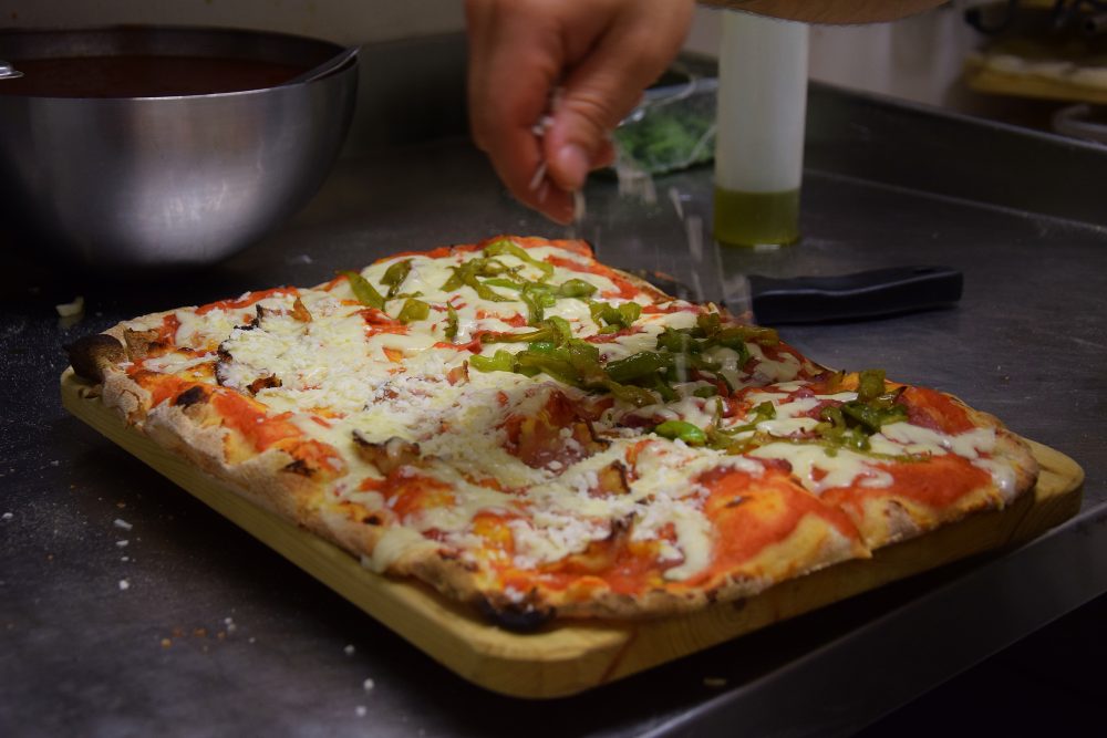 Accussi' - Meta' San Marzano DOP, fiordilatte di Agerola, salamino di maialino casertano nero, peperoni friggitelli - Meta' San Marzano DOP, guanciale di maialino nero casertano, pecorino romano IGT