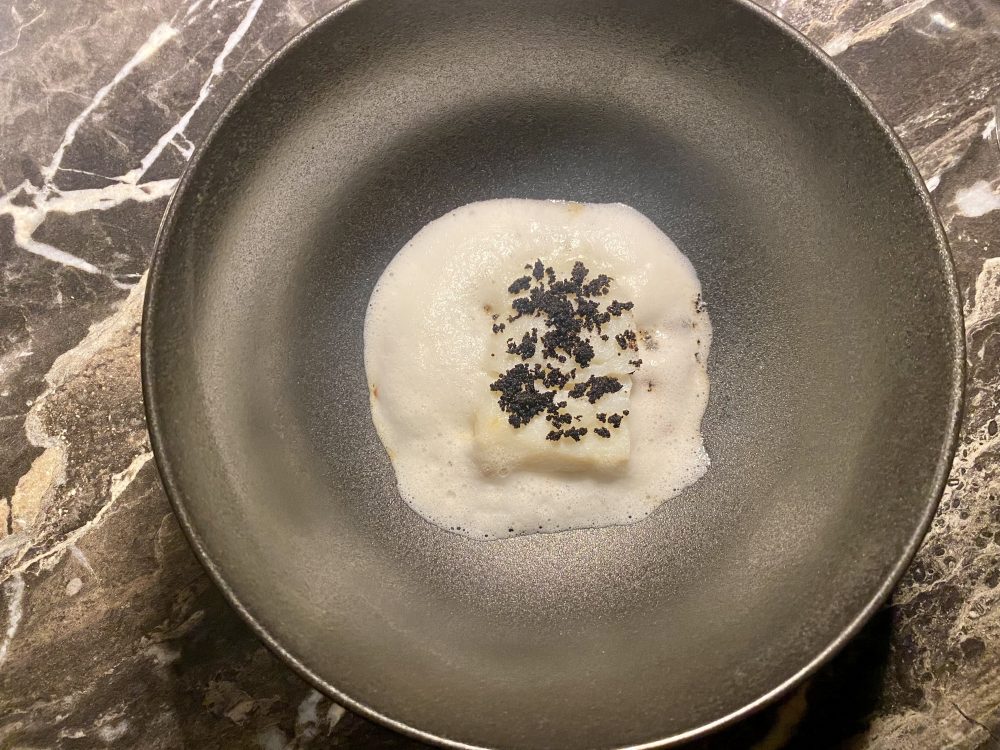 Baccala', con conserva di corbarino, radici, baccalà cotto al latte, aria di aglio e latte, terra di olive e cacao - Radici Clandestine