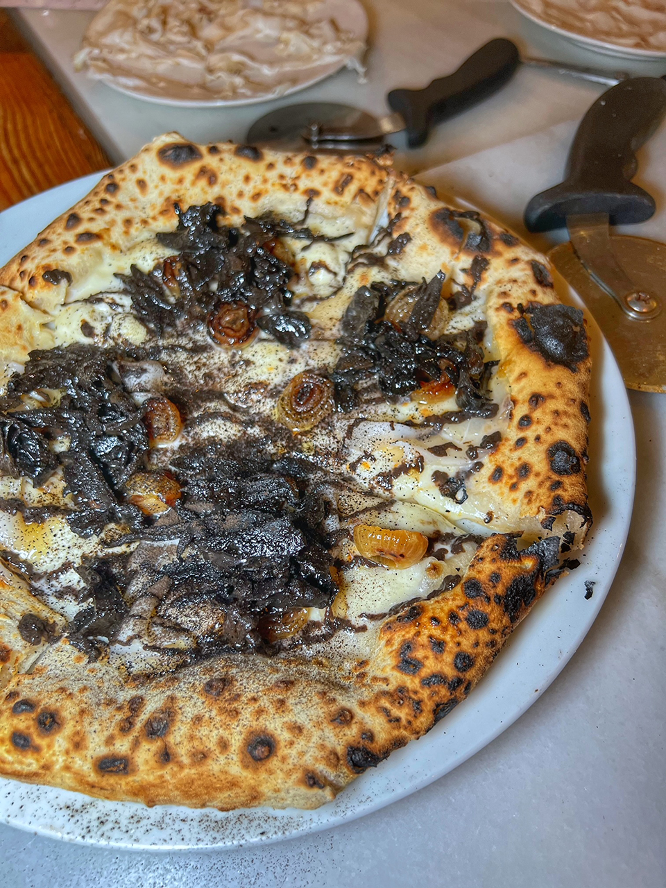 Pizza con funghi trombetta nera, mozzarella, lardo de Gascón e cipolla a la brasa encurtida by Sartoria Panatieri