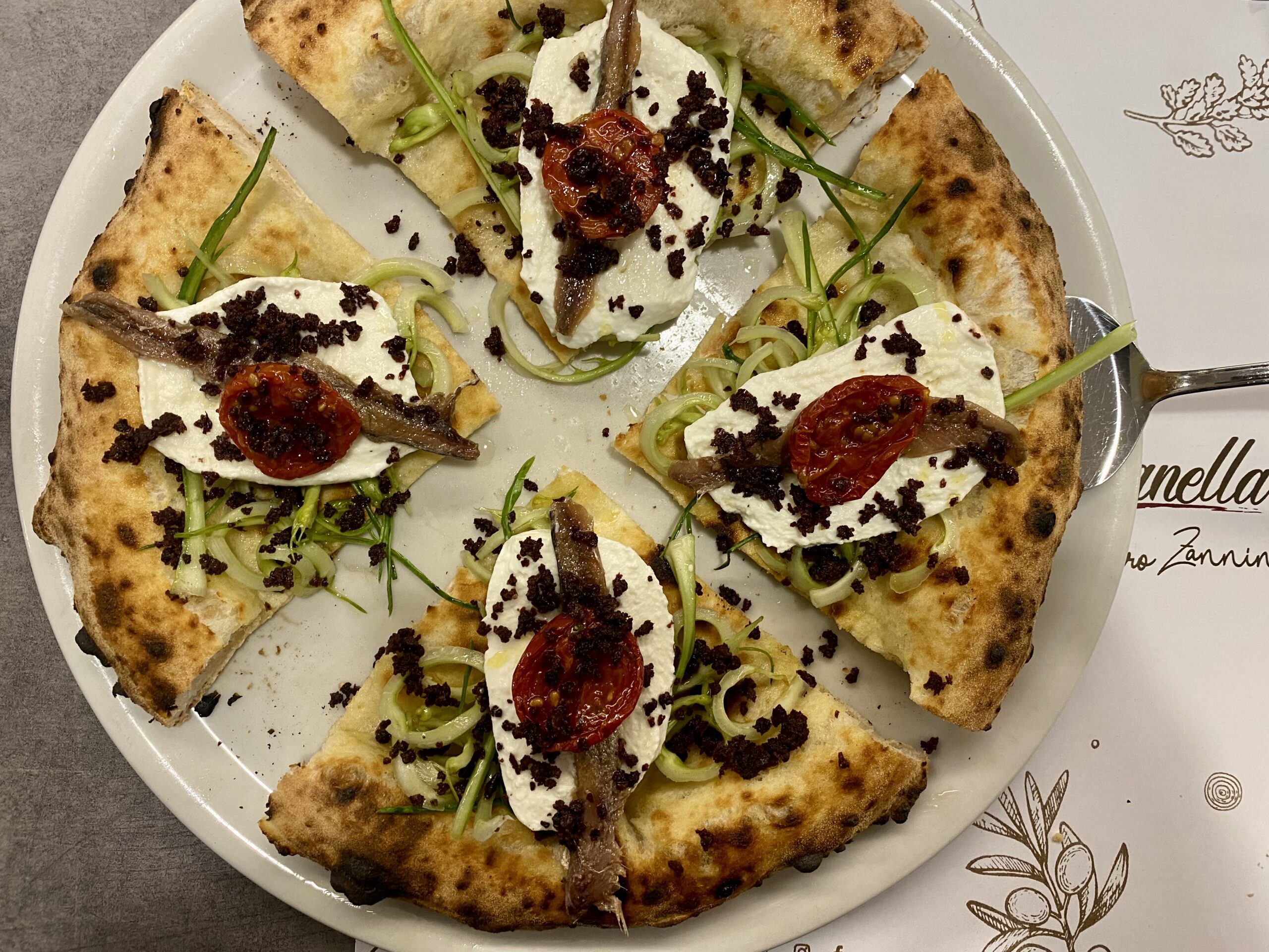 Vacanze-Romane-Focaccia-con-puntarella-aromatizzata-allaglio-olio-bufala-fresca-alici-di-Cetara-polvere-di-olive-nere-di-Gaeta-pomodorino-semi-dry-olio-Evo-22Cantine-S