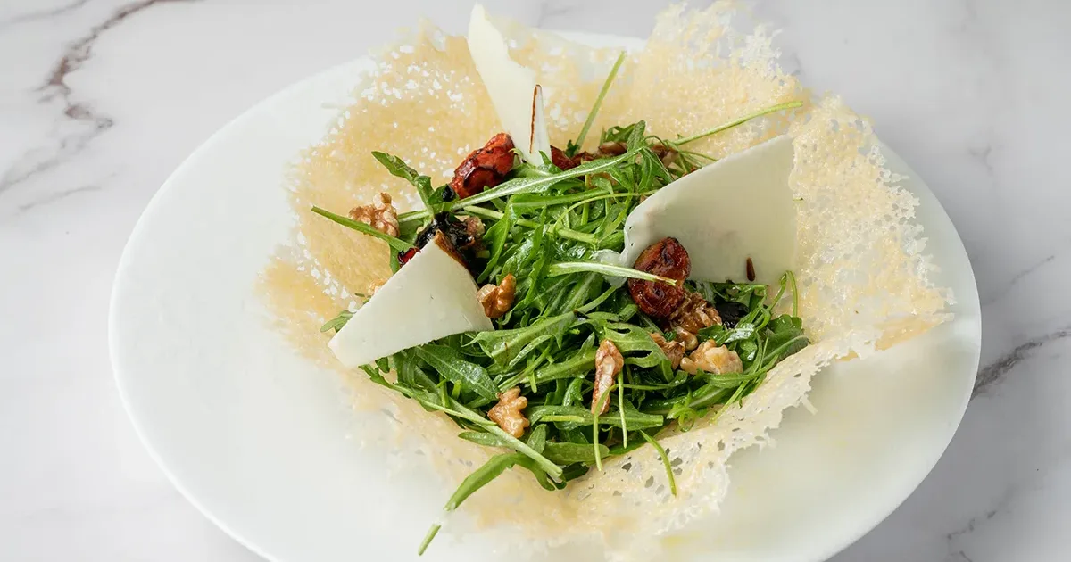 Cestino di parmigiano con insalatona di rucola, noci, pomodorini, scaglie di pecorino ed aceto balsamico