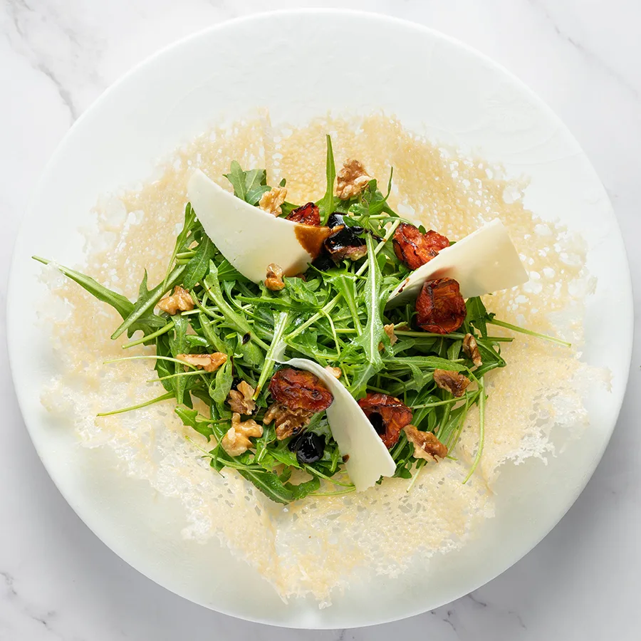 Cestino di parmigiano con insalatona di rucola, noci, pomodorini, scaglie di pecorino ed aceto balsamico