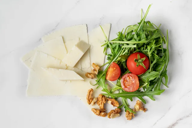 Cestino di parmigiano con insalatona di rucola, noci, pomodorini, scaglie di pecorino ed aceto balsamico