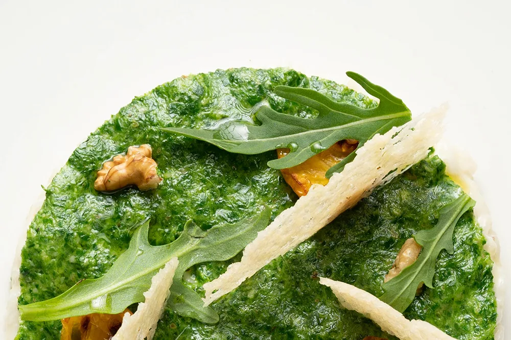 Risotto al Parmigiano Reggiano, pesto di rucola e pomodorini infornati