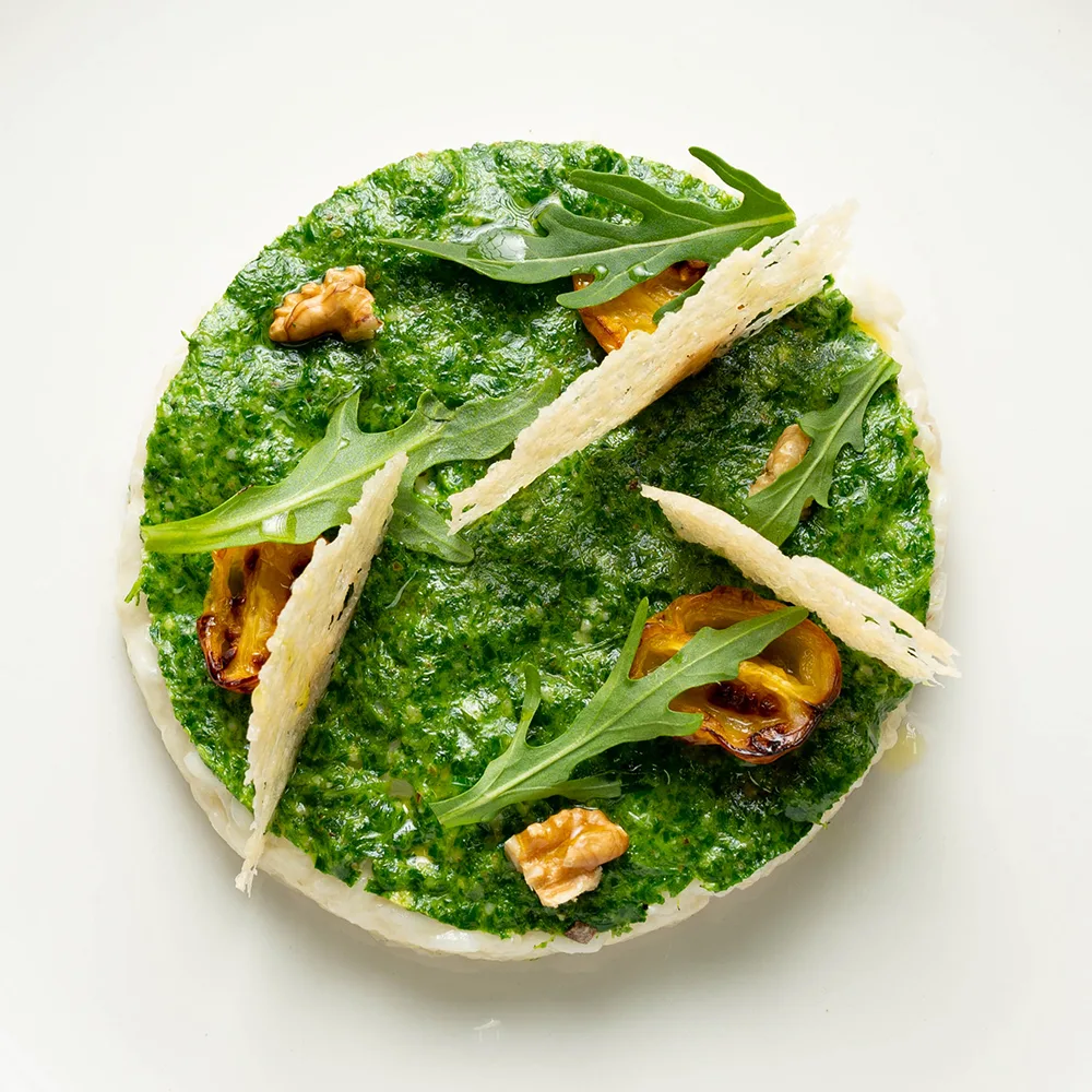 Risotto al Parmigiano Reggiano, pesto di rucola e pomodorini infornati