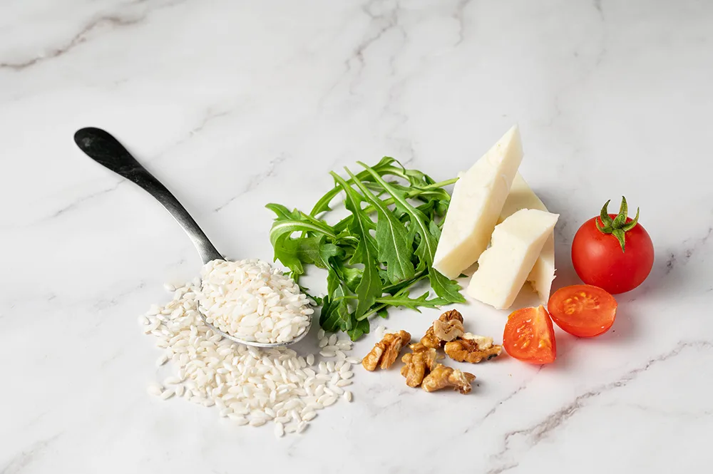 Risotto al Parmigiano Reggiano, pesto di rucola e pomodorini infornati