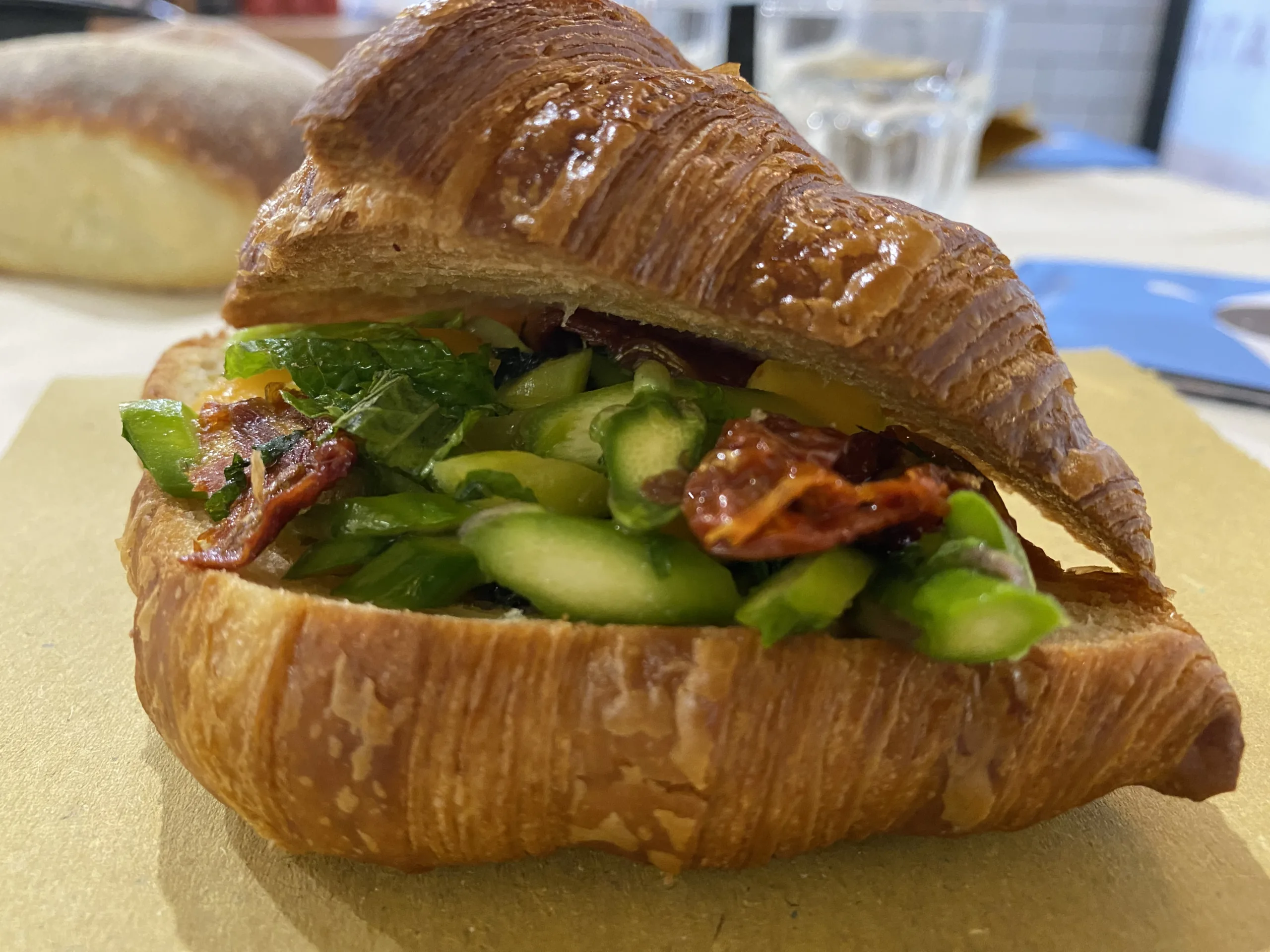 Croissant-salato-con-burrata-affumicata-insalata-di-asparagi-albicocca-del-vesuvio-pomodorino-del-Vesuvio-semi-dry-limone-menta-e-maggiorana