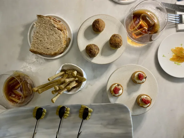 Amouse-Bouche-Vermouth-con-scorza-di-limone-e-semi-di-finocchio-con-Bottarga-home-made-Crocchetta-di-coda-alla-vaccinara-Anguilla-zucchine-alla-scapece-e-ciliegia-Pecorino-vongole-e-pomodoro
