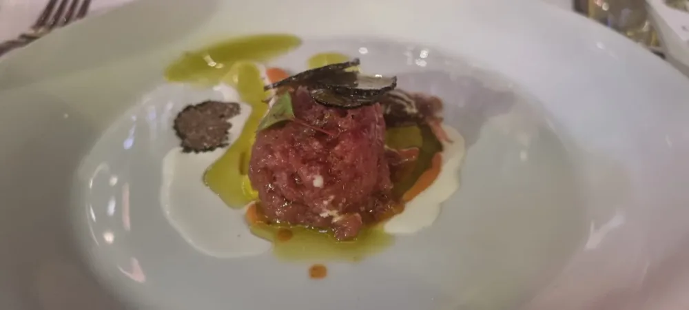 Tartare di manzo al profumo di peperone rosso arrosto, tartufo nero e cipolla marinata con olio Carolea (Librandi)
