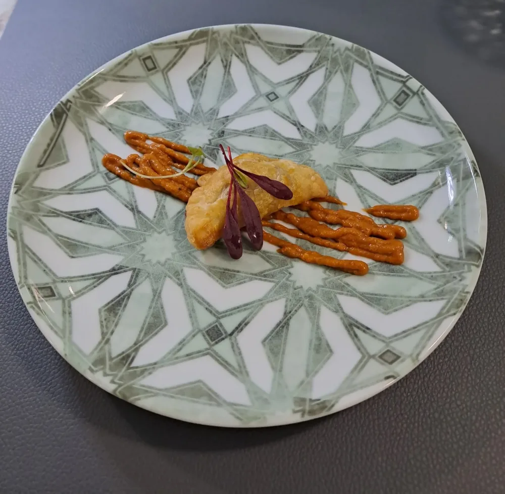 Roan, sfoglino con provola, scarole e salsiccia di maialino nero casertano su pesto alla mediterranea