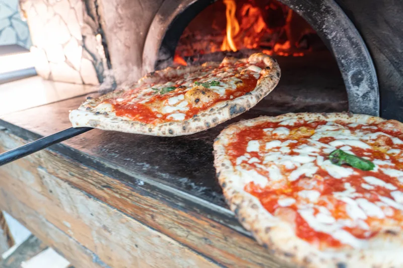 Il forno della pizzeria San Ciro con pizze margherite in uscita