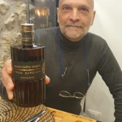Pino Perrone con la bottiglia di Whisky di Silvio Carta