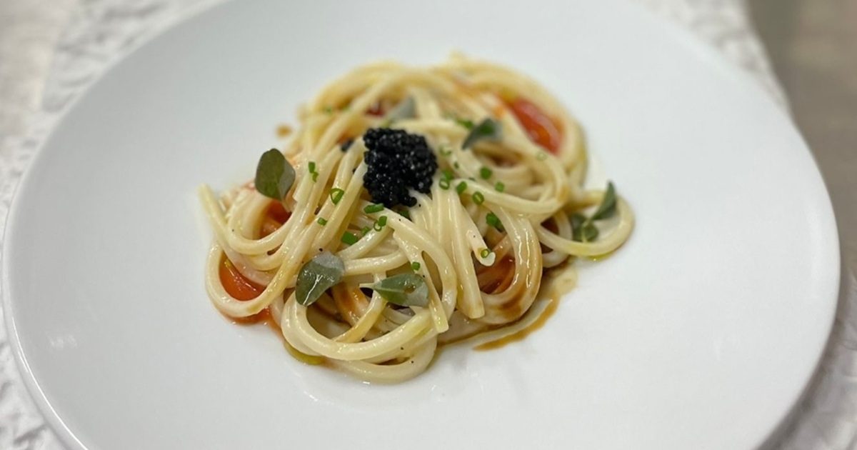 Spaghetto alla chitarra, estrazione e garum di croste di parmigiano, pomodoro in papillote e cipolle di Acquaviva: la ricetta di Giuseppe Amato